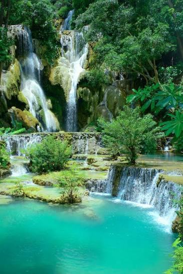 Peaceful cascades of Khonepasoi waterfall surrounded by green trees