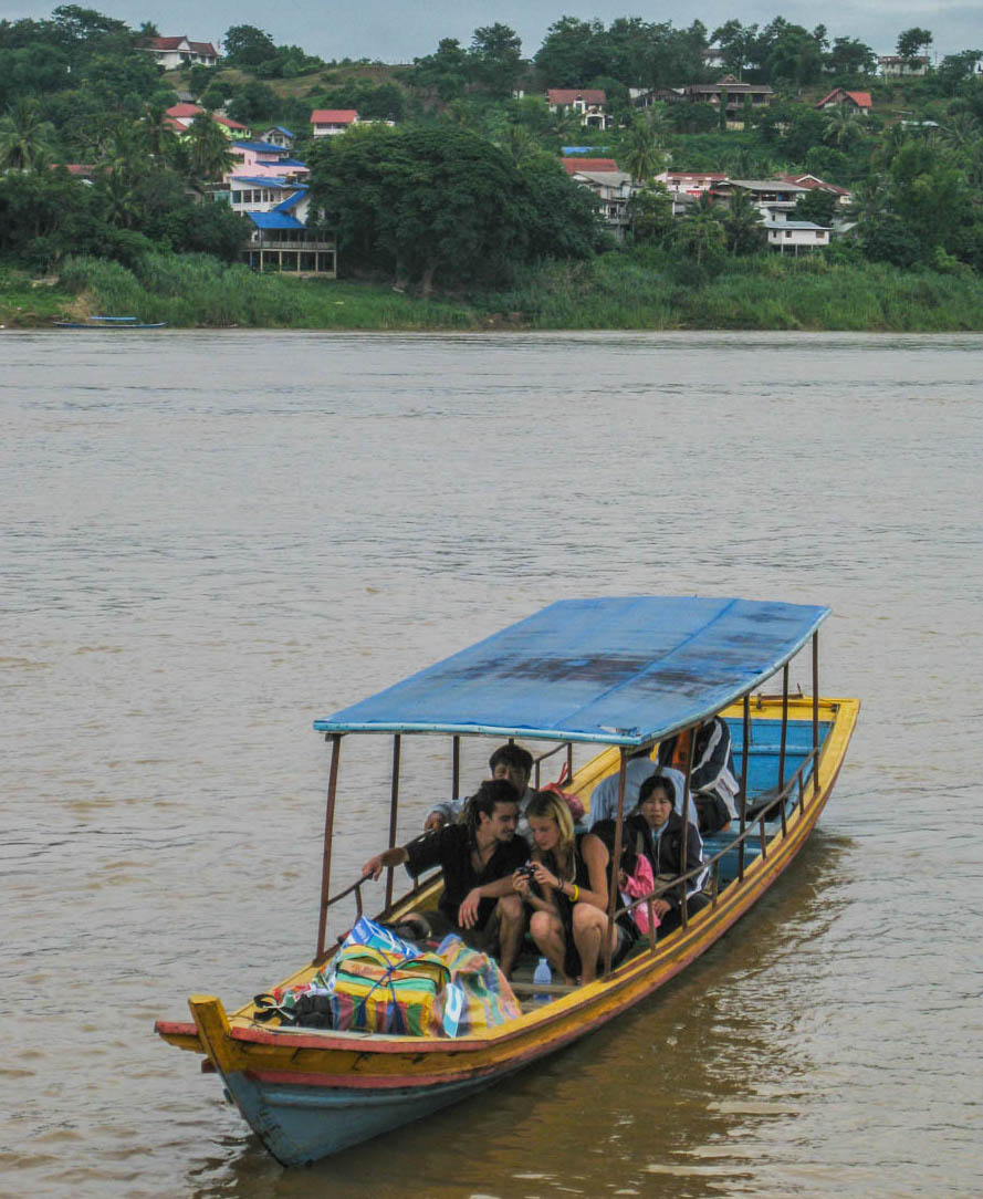 A local wooden platform ferry carrying vehicles across the Mekong River